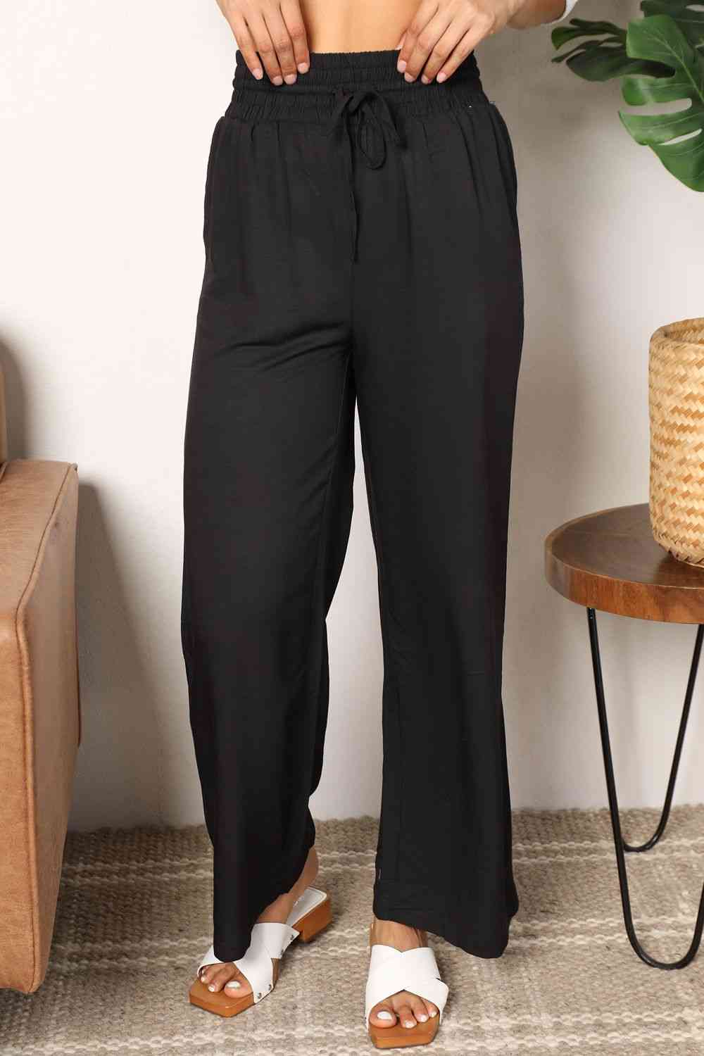 Crafted with a drawstring-smocked waist, these Women's wide-leg pants offer comfort and a flattering silhouette. Their extended length exudes elegance, making them suitable for casual or formal settings. Effortlessly stylish and versatile, these pants are an excellent choice for creating trendy yet comfortable ensembles.
